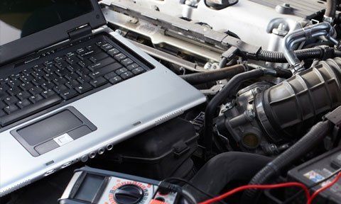laptop on a open vehicle engine 