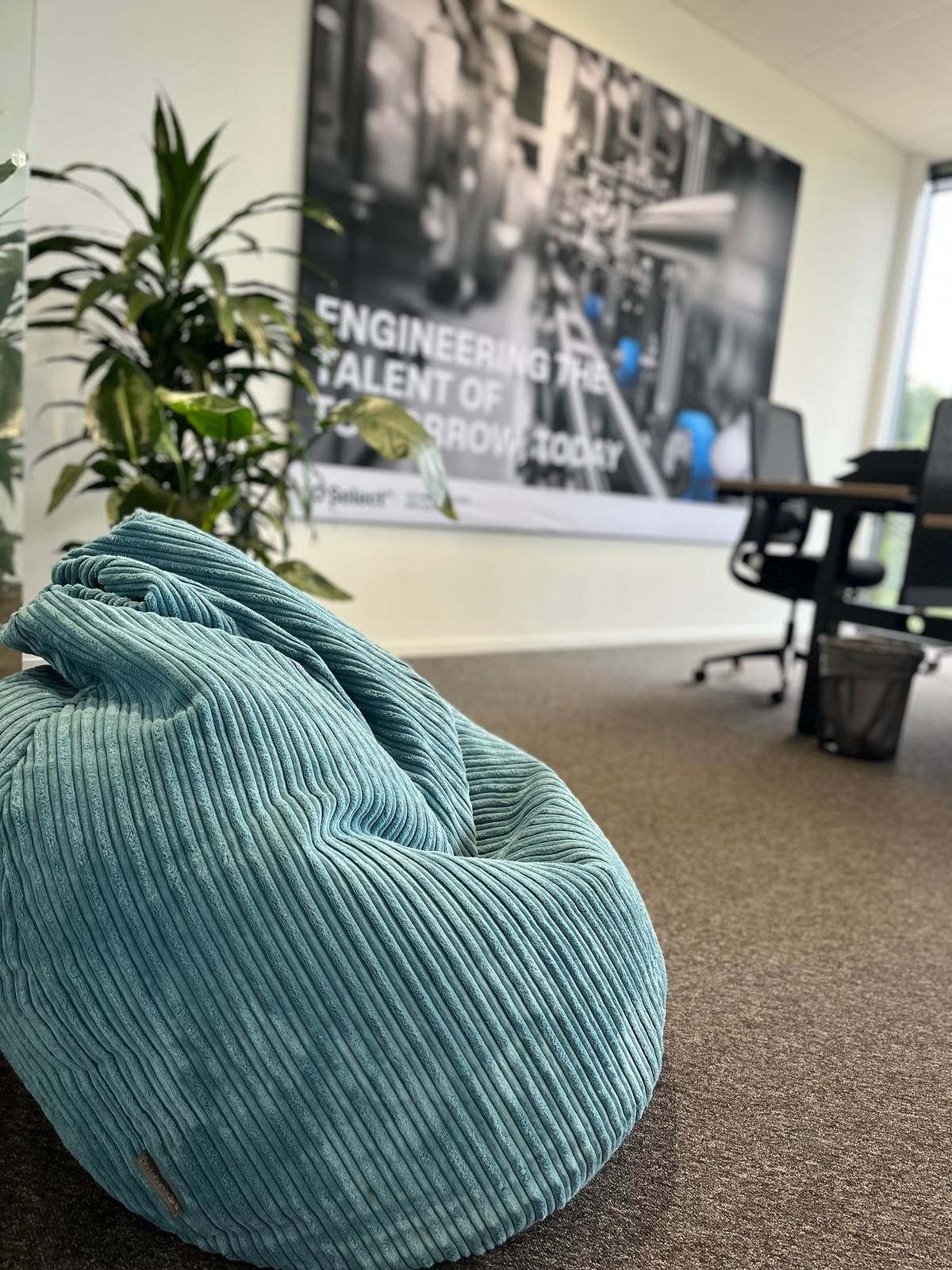 Blue corduroy beanbag chair in a modern office.