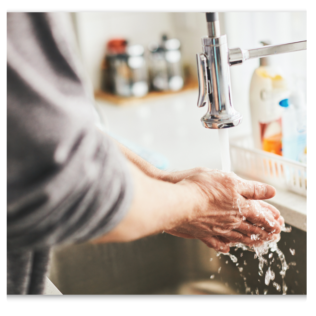 Man washing hands under kitchen faucet