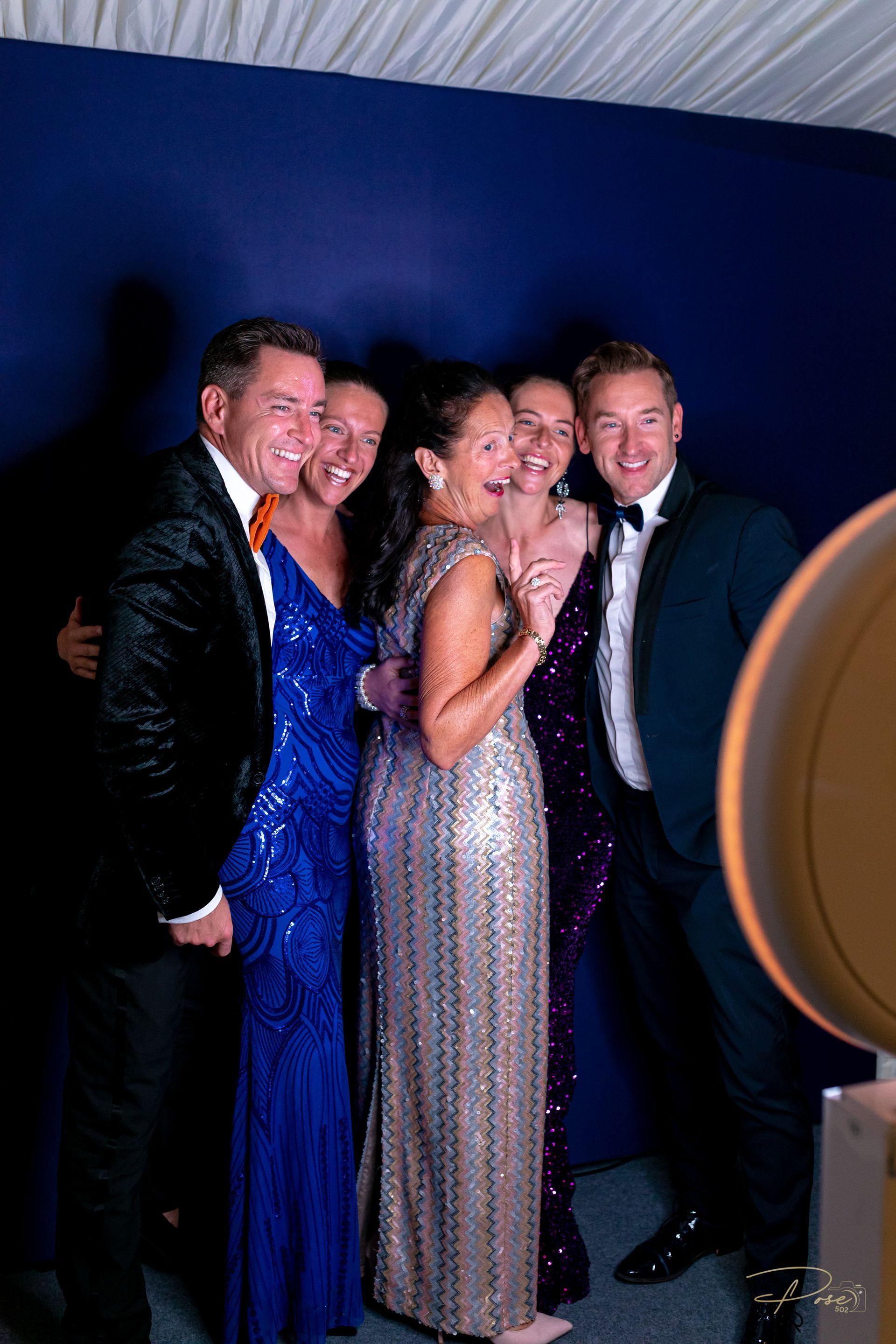 Two men and two women taking a photo with the digital selfie booth at a wedding or gala