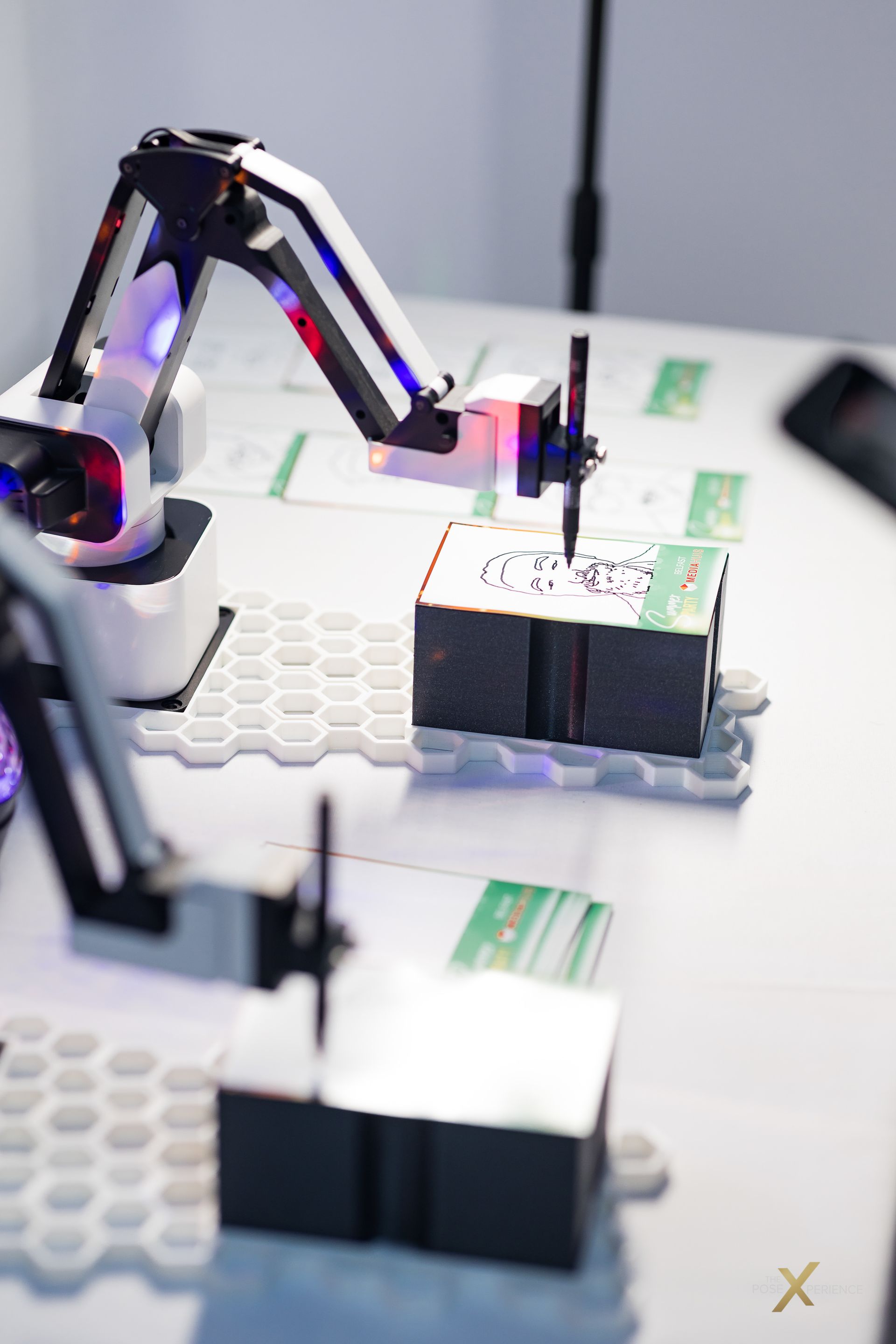 Man in white button-down shirt smiles, looking over his shoulder against a black background.