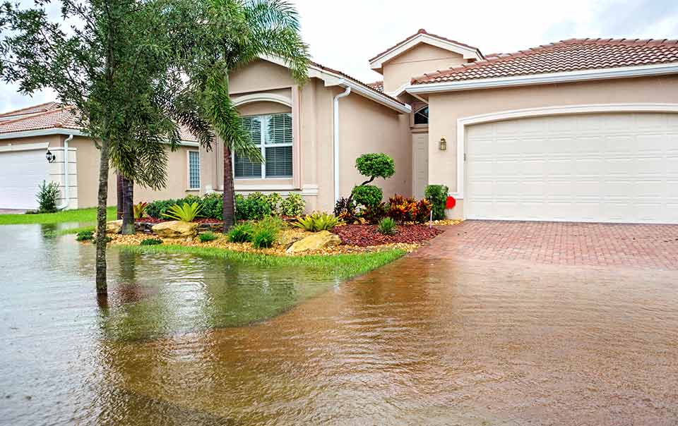 A flooded driveway in front of a house.