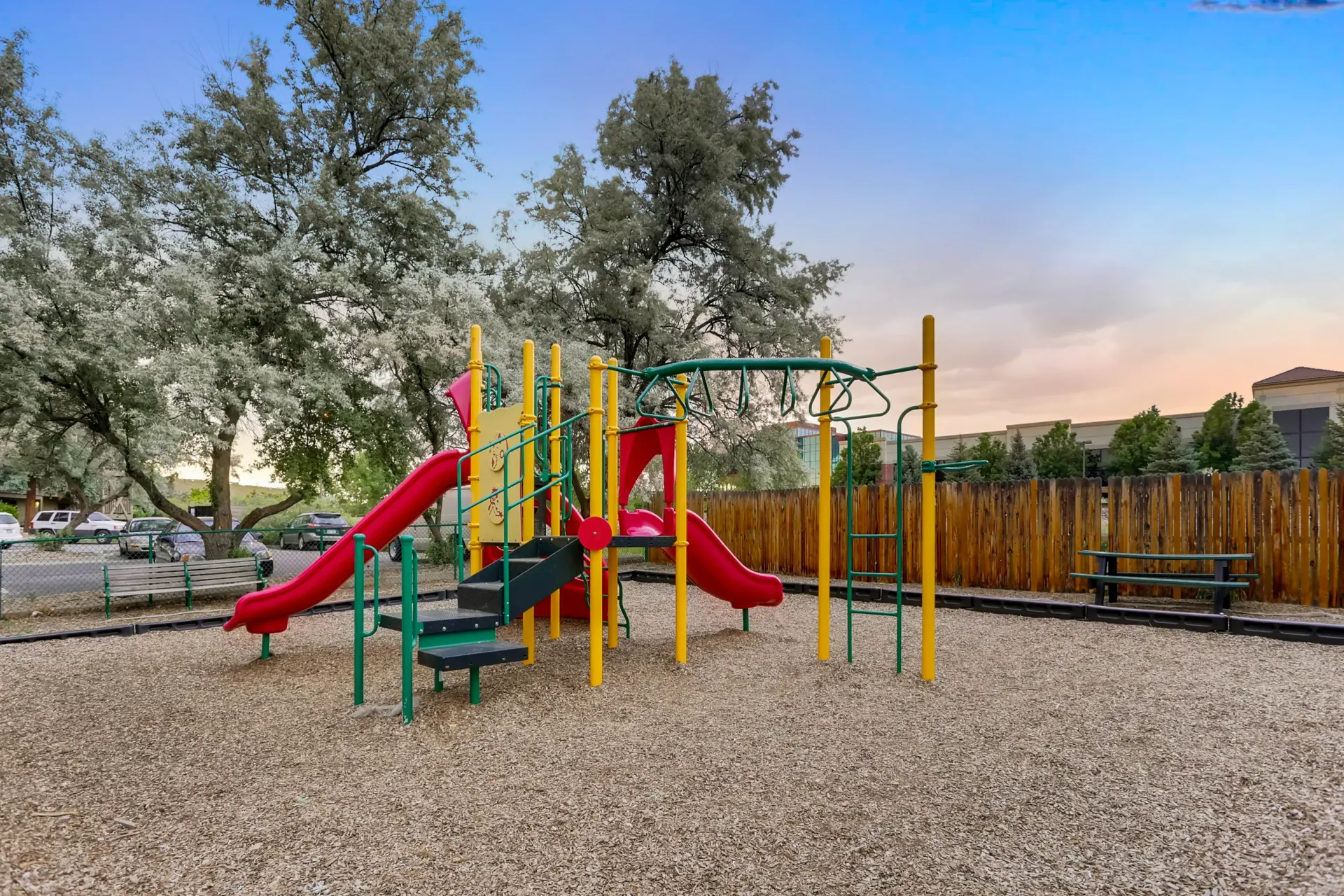 Colorful outdoor playground with slides and climbing structures at an apartment community.