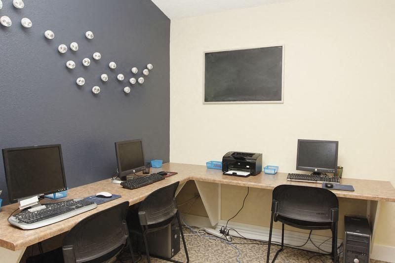 Community computer lab with multiple desks, monitors, keyboards, and a printer.