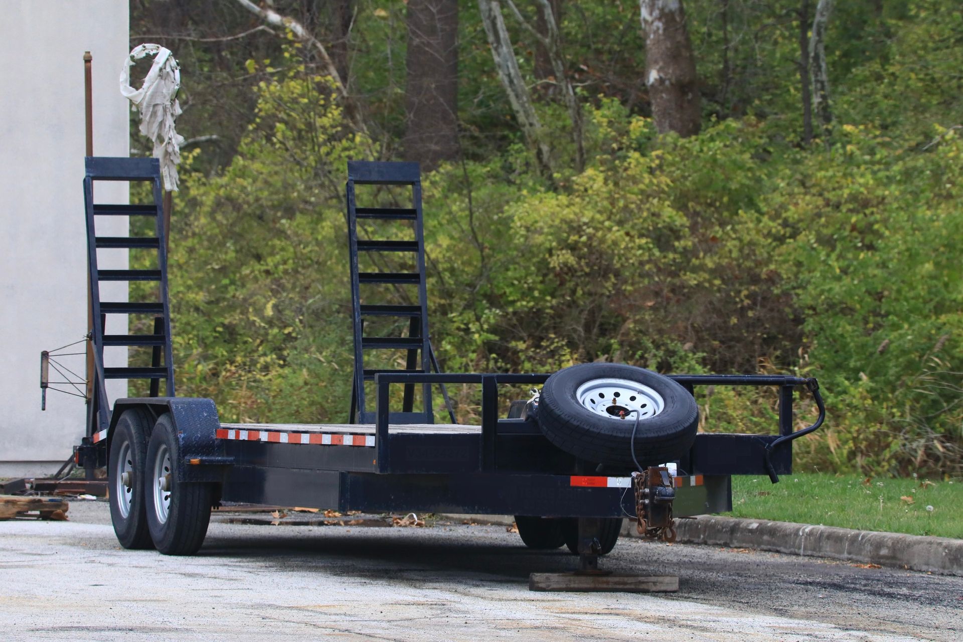 A trailer is parked in a parking lot with trees in the background