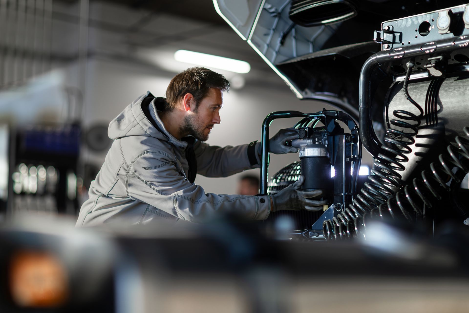 A man is working on a truck in a garage.