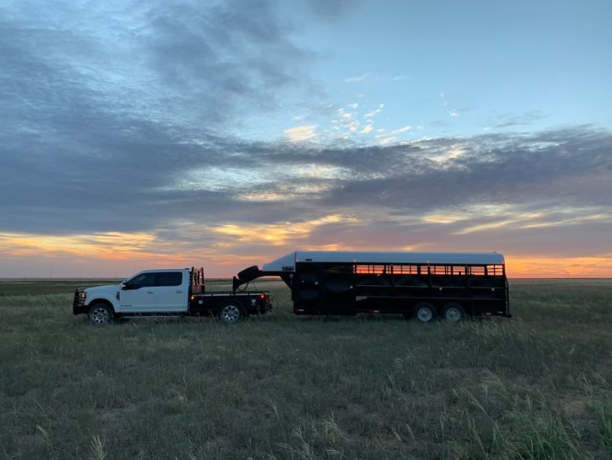 A black semi truck is parked on the side of the road.