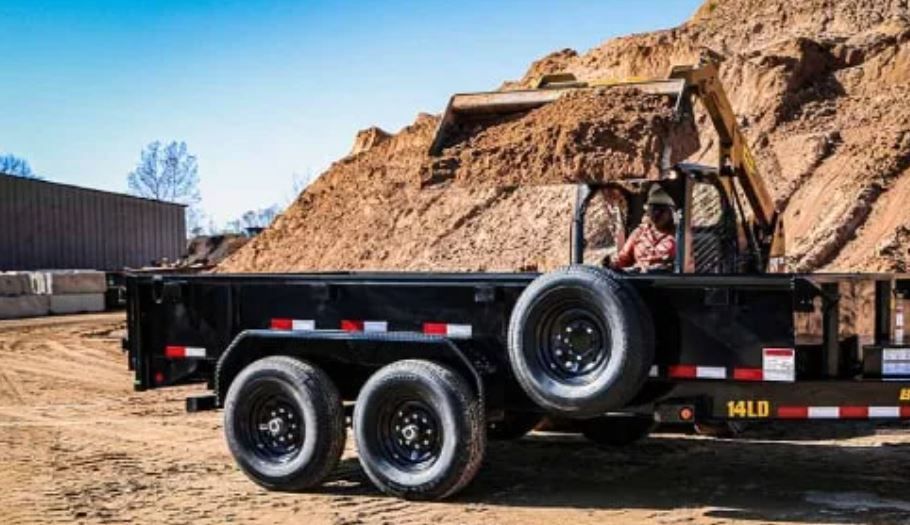 A flatbed trailer is parked on the side of the road
