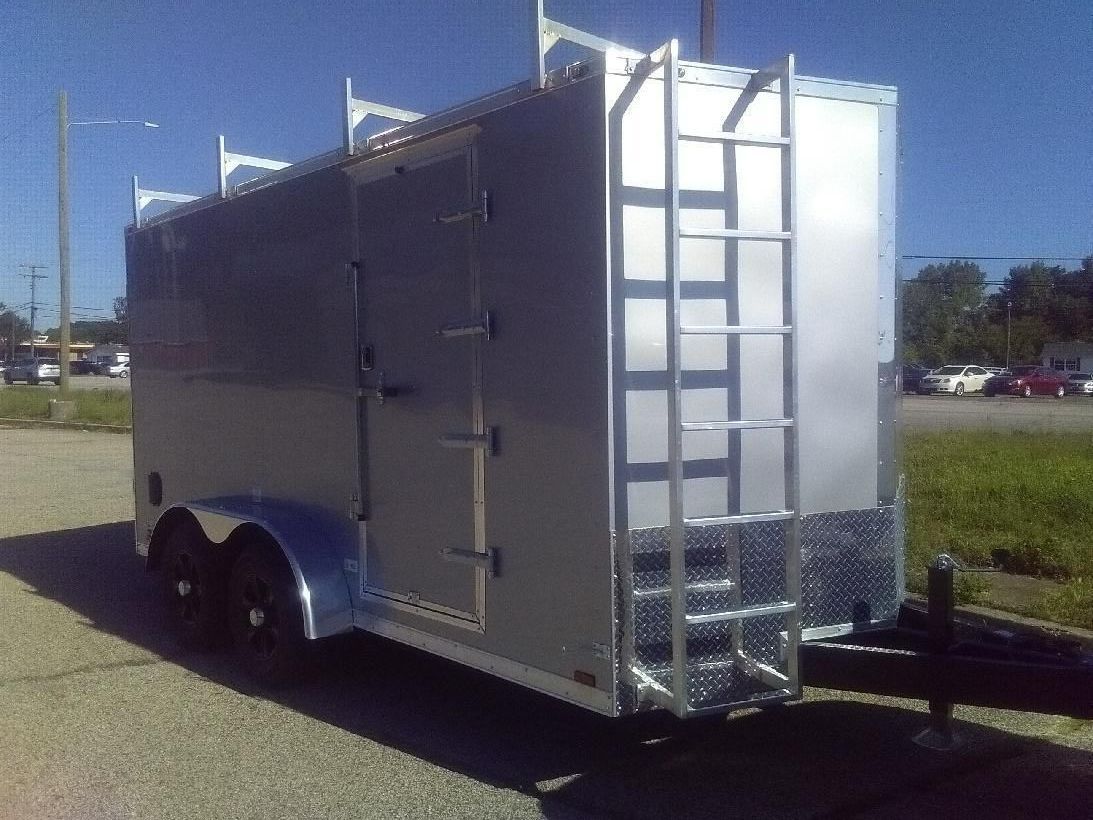 A white trailer is parked on a gravel road