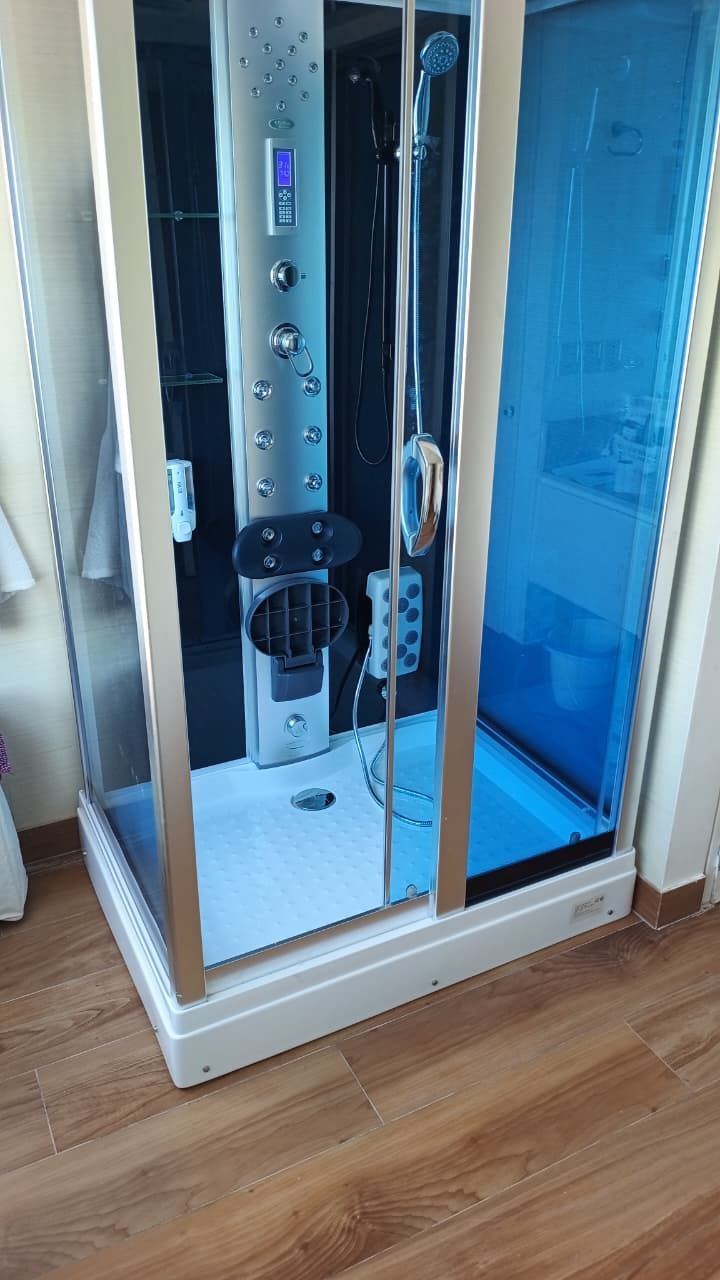 Mampara de ducha moderna con cristal tintado en azul y múltiples chorros de ducha.