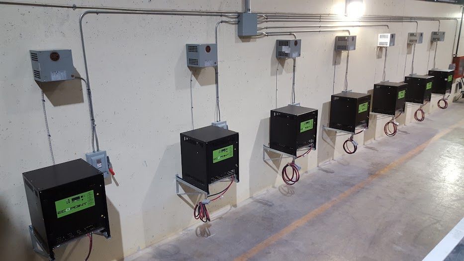 Une rangée de boîtes noires accrochées au mur d'une pièce.