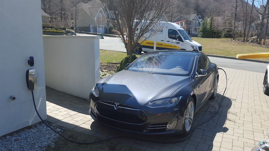 Une Tesla Model S est en cours de charge dans une borne de recharge.