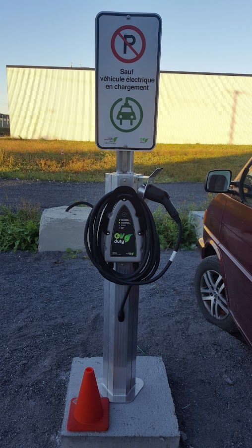 Une voiture est en cours de recharge sur une borne de recharge dans un parking.