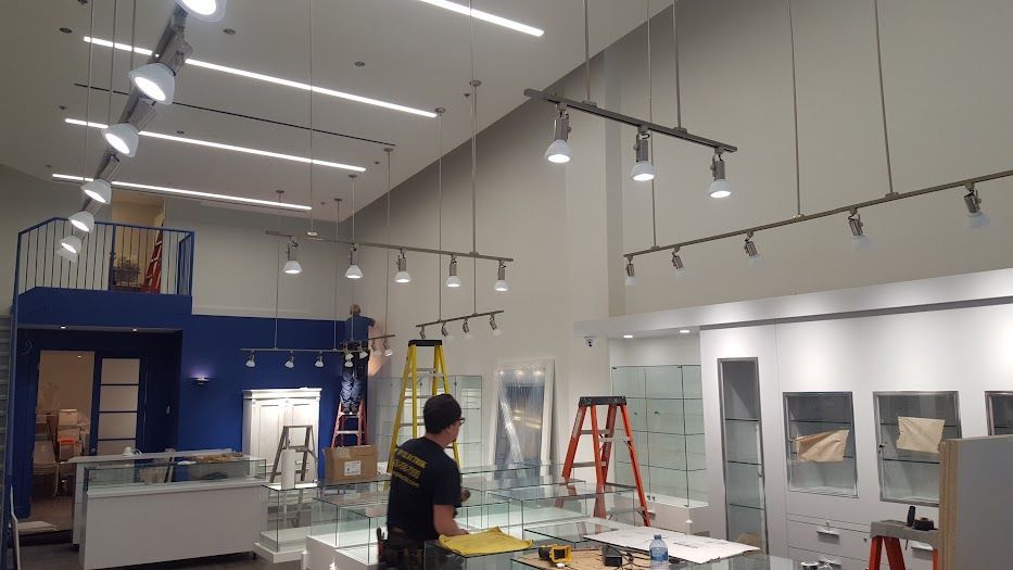 Un homme se tient debout dans une grande pièce avec une échelle.