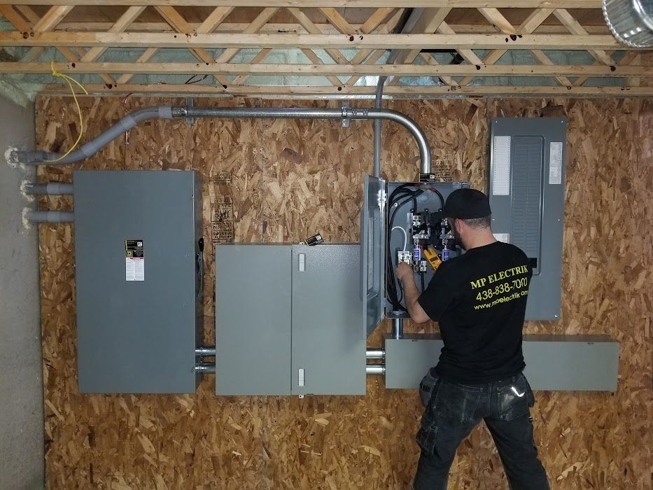 Un homme travaille sur un boîtier électrique dans une pièce.