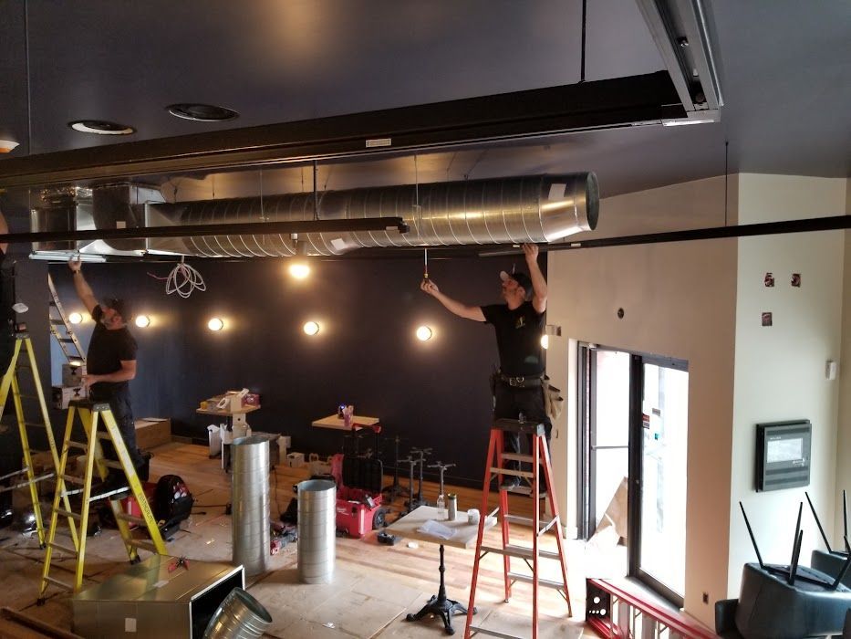 Un groupe de personnes travaille sur le plafond d'un bâtiment.