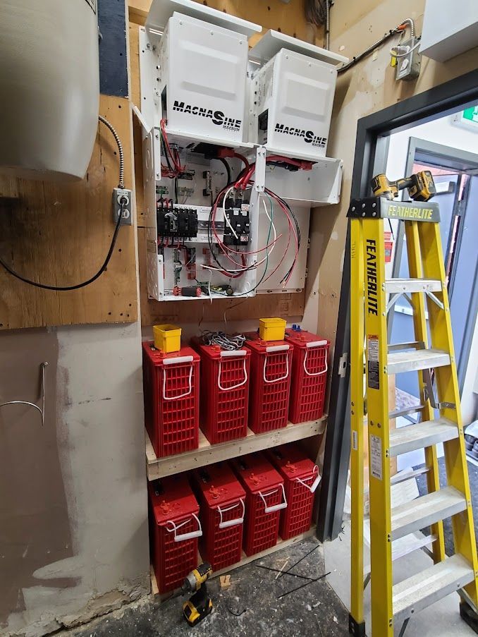 Une échelle est posée à côté d'une étagère remplie de piles rouges.