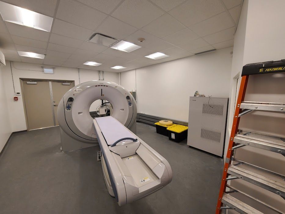 Un appareil de tomodensitométrie est installé dans une pièce à côté d'une échelle.