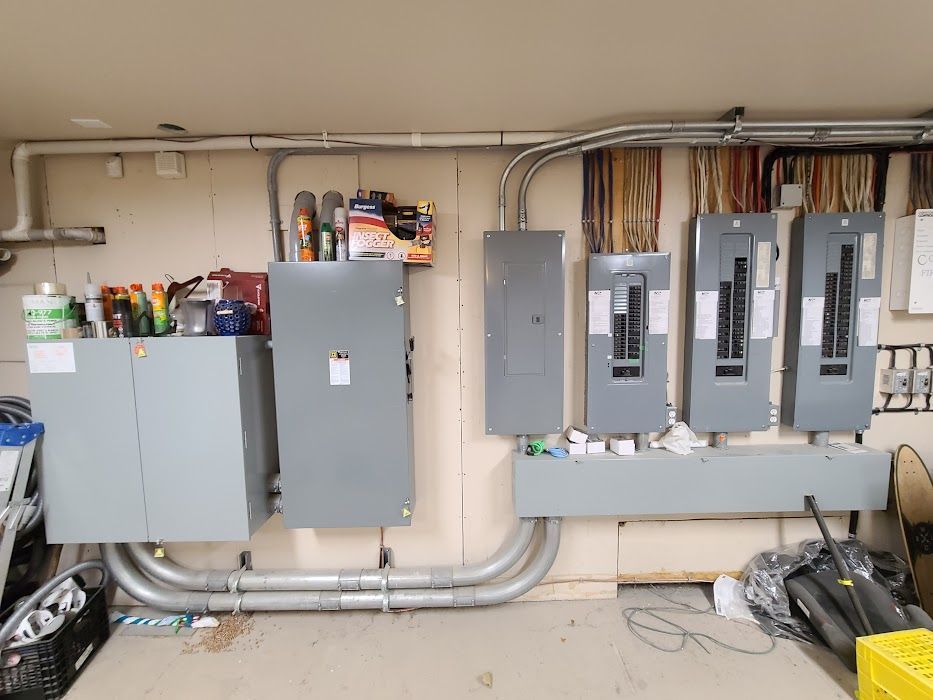 Un tas de panneaux électriques sont accrochés à un mur dans un garage.