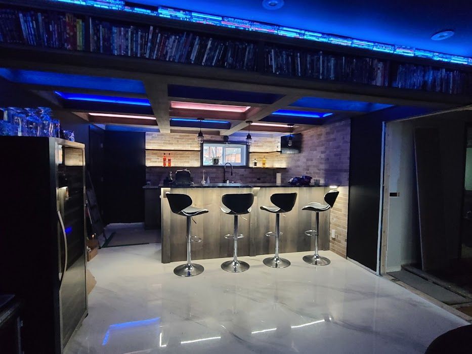 Un bar avec des tabourets et un réfrigérateur dans un sous-sol.