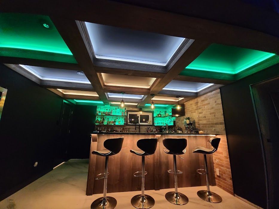 Un bar avec des tabourets et des lumières vertes au plafond