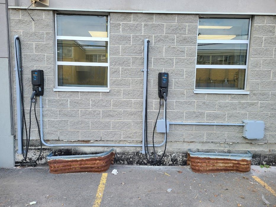 Un bâtiment en briques avec deux bornes de recharge sur le côté
