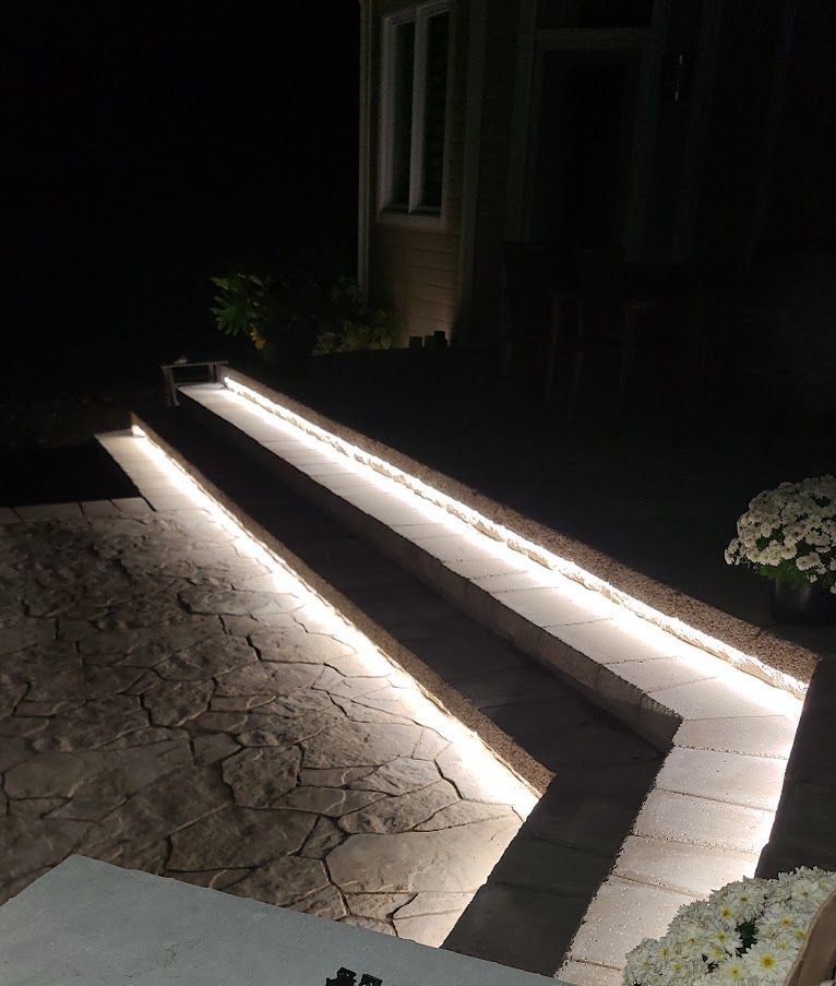 Une passerelle avec des lumières est éclairée la nuit.