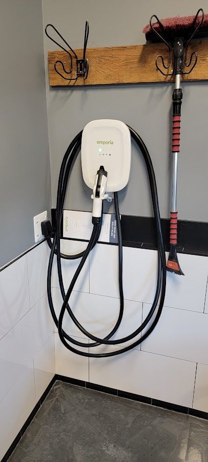 Un chargeur de voiture électrique est accroché au mur d'un garage.