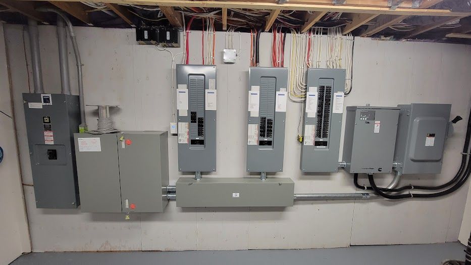 Un tas de panneaux électriques sont accrochés au mur d'une pièce.