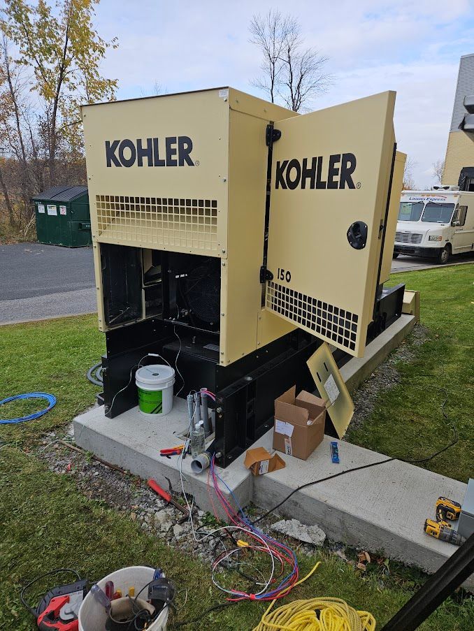 Un générateur Kohler est posé sur une plate-forme en béton dans l'herbe.