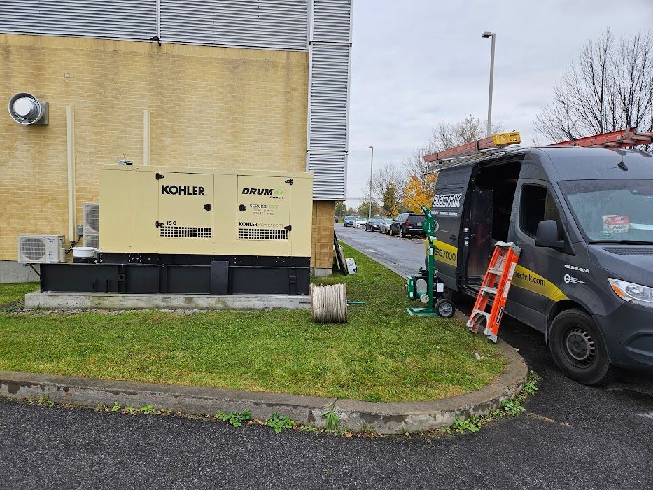 Une camionnette est garée devant un bâtiment à côté d'un générateur.
