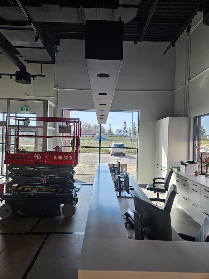 Un élévateur à ciseaux est installé dans une pièce avec une longue table et des chaises.