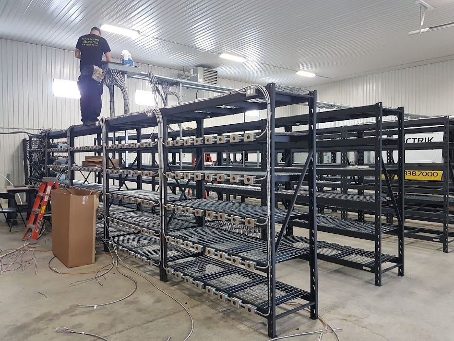 Un homme se tient debout sur un support métallique dans un entrepôt.