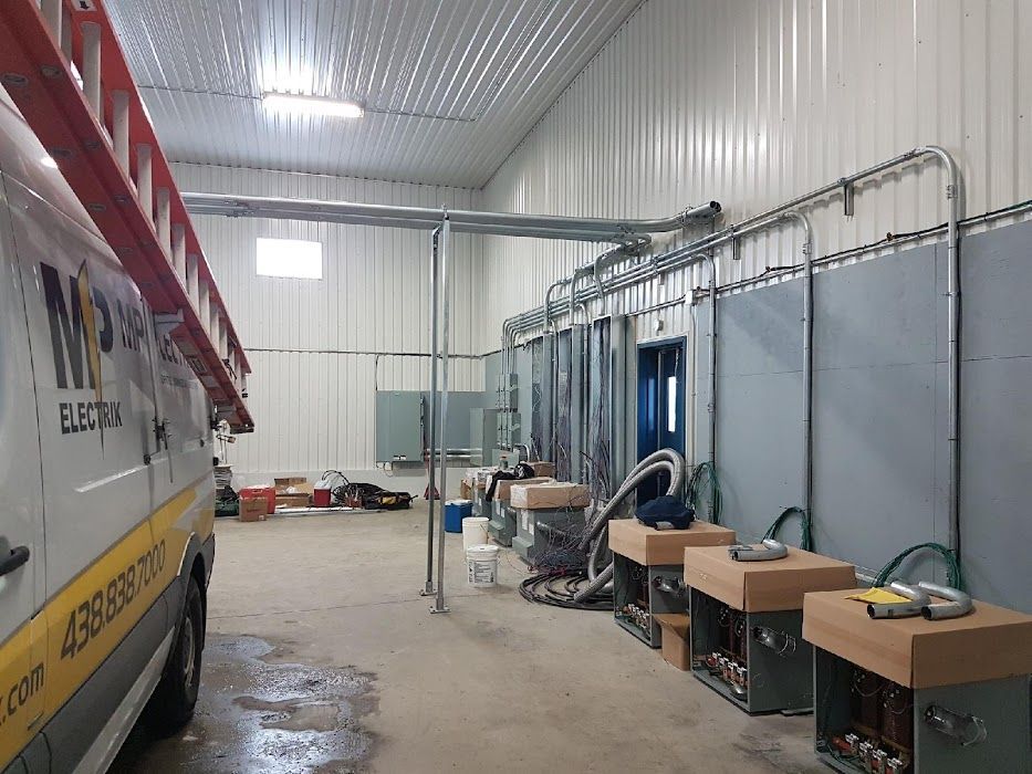 Une camionnette avec une échelle dessus est garée à l'intérieur d'un bâtiment.