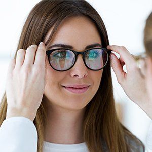 Prescription Sunglasses — Optometrist and Young Woman Choosing Eyeglasses in Manasquan, NJ