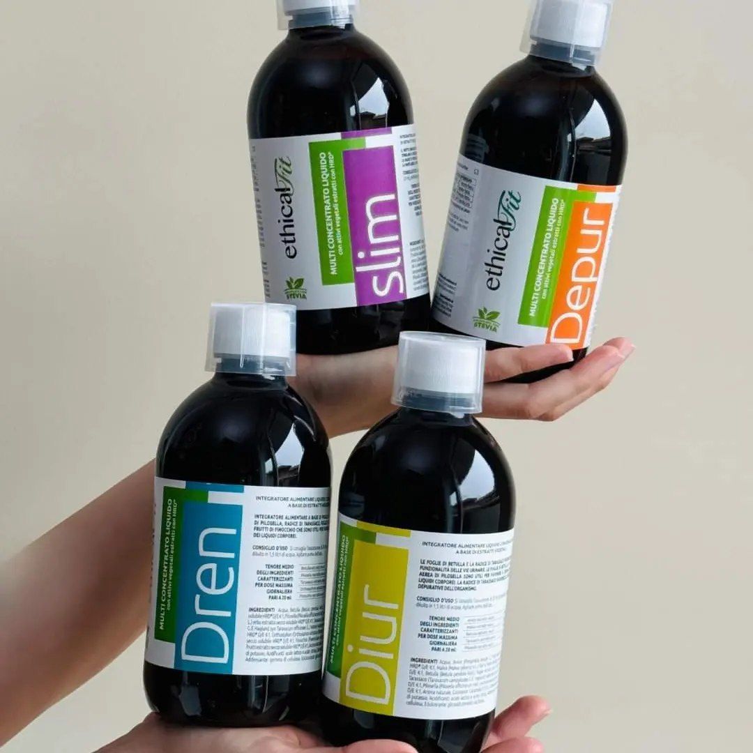 Quattro bottiglie di liquido scuro, tenute in due mani. Le etichette dicono 