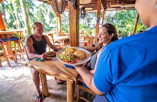 A man and a woman are sitting at a table with a plate of food.