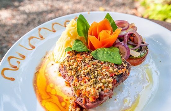 A white plate topped with a piece of meat and vegetables.