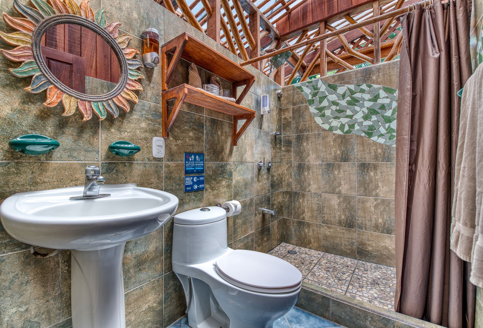 A bathroom with a toilet , sink and shower.