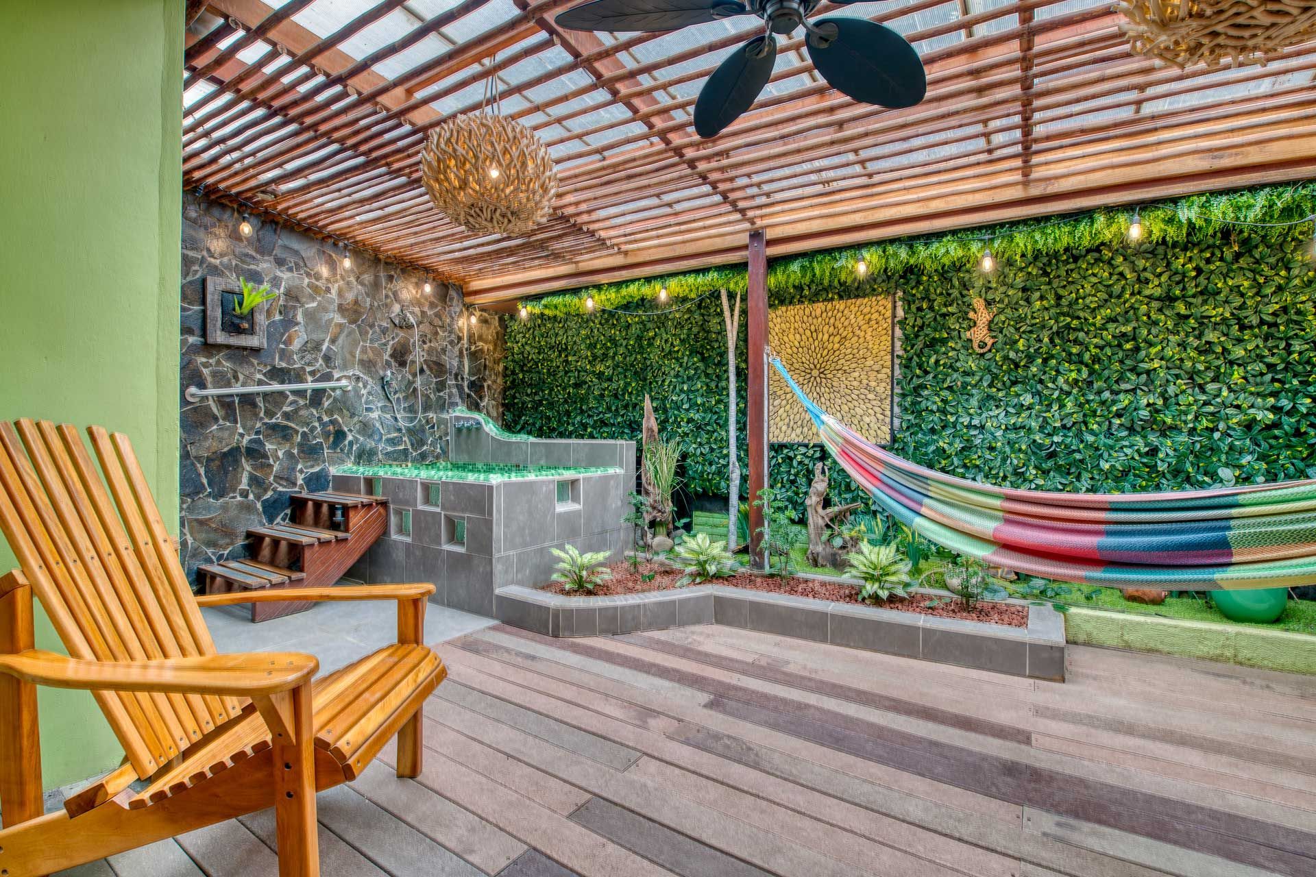 A wooden deck with a hammock and a ceiling fan.