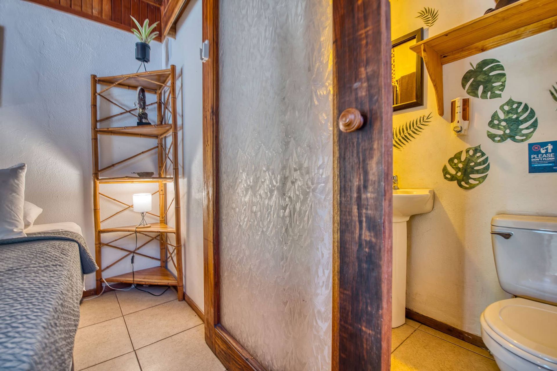 A bathroom with a toilet , sink and mirror.
