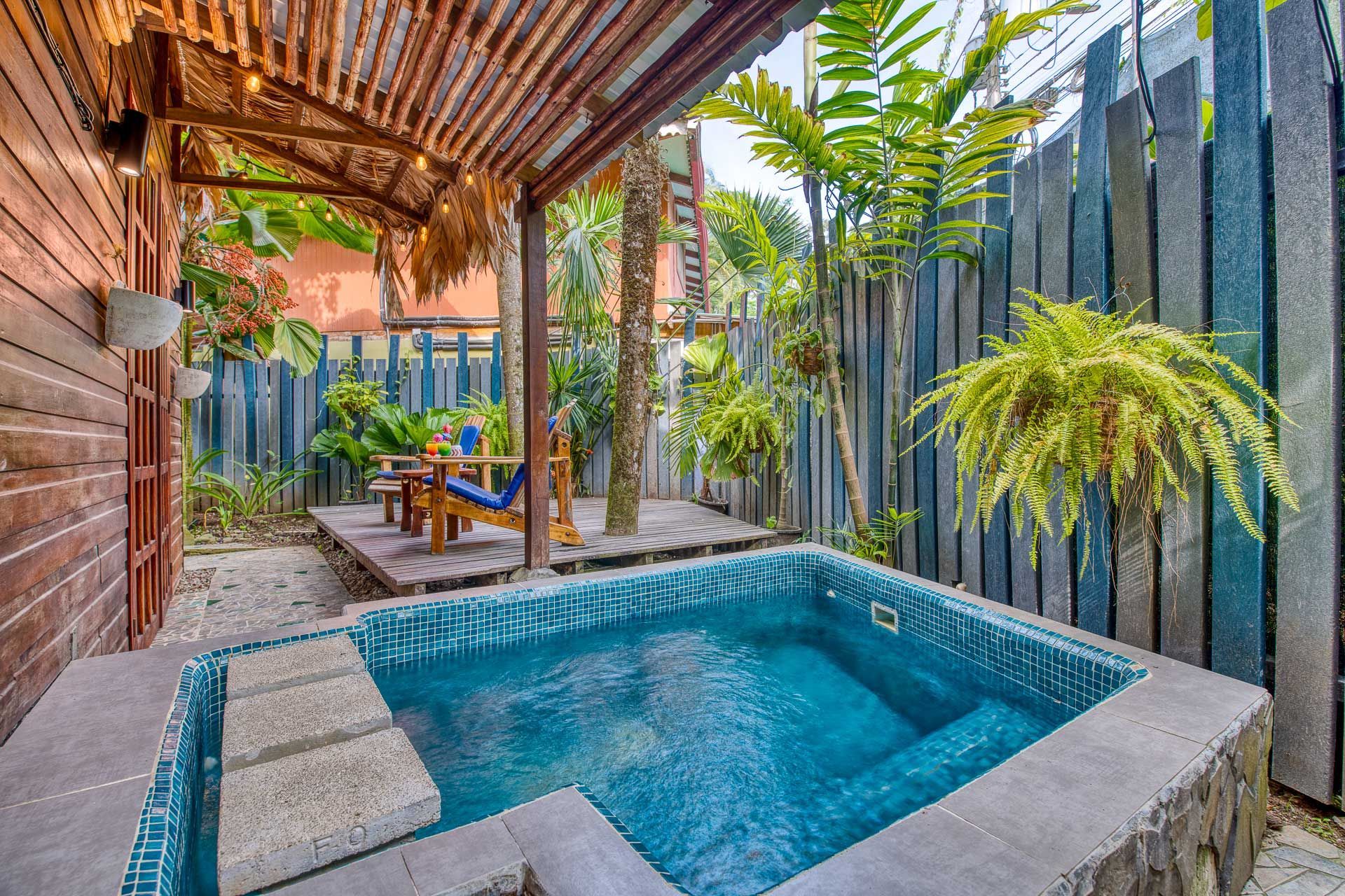 There is a small swimming pool in the backyard of a house.