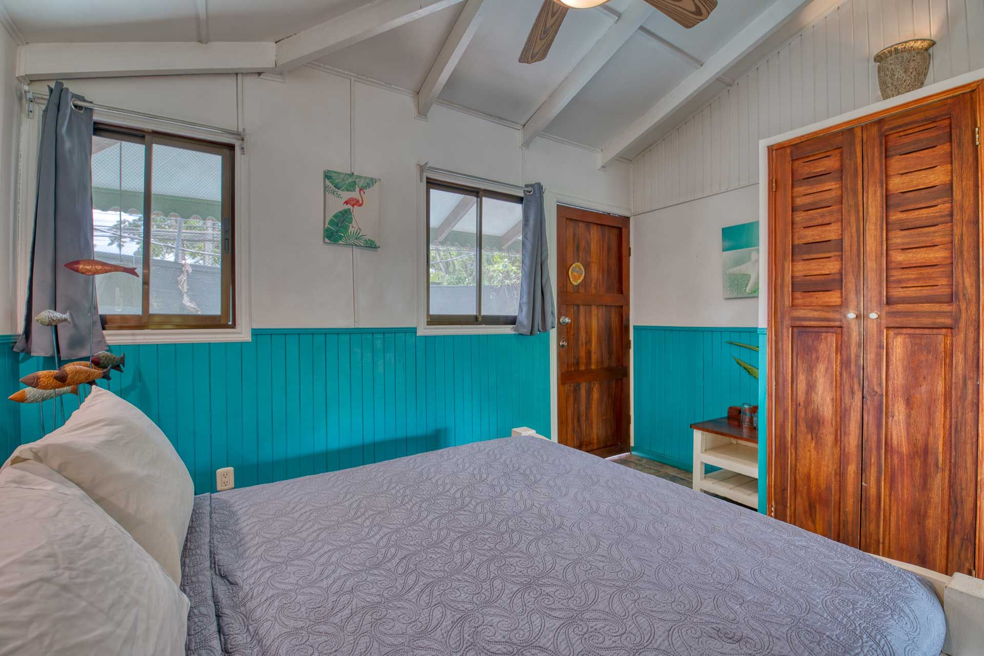 A bedroom with a bed and a ceiling fan