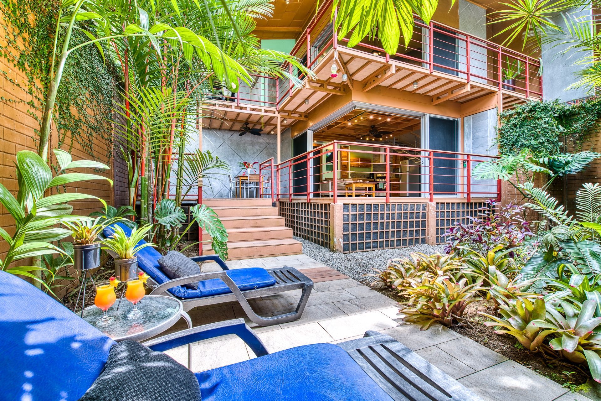 A patio with chairs and a table in front of a house.