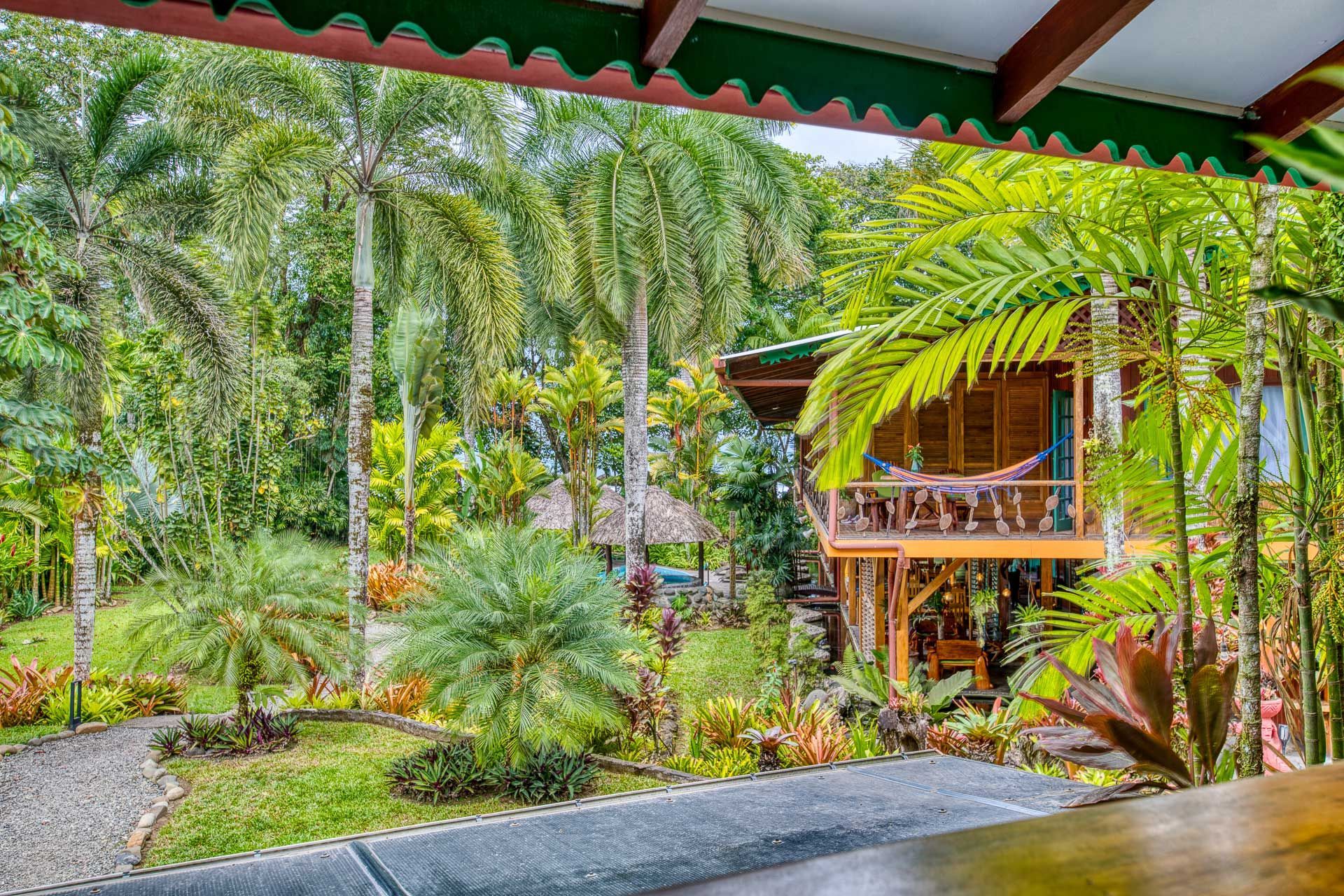 A wooden house in the middle of a lush green forest.