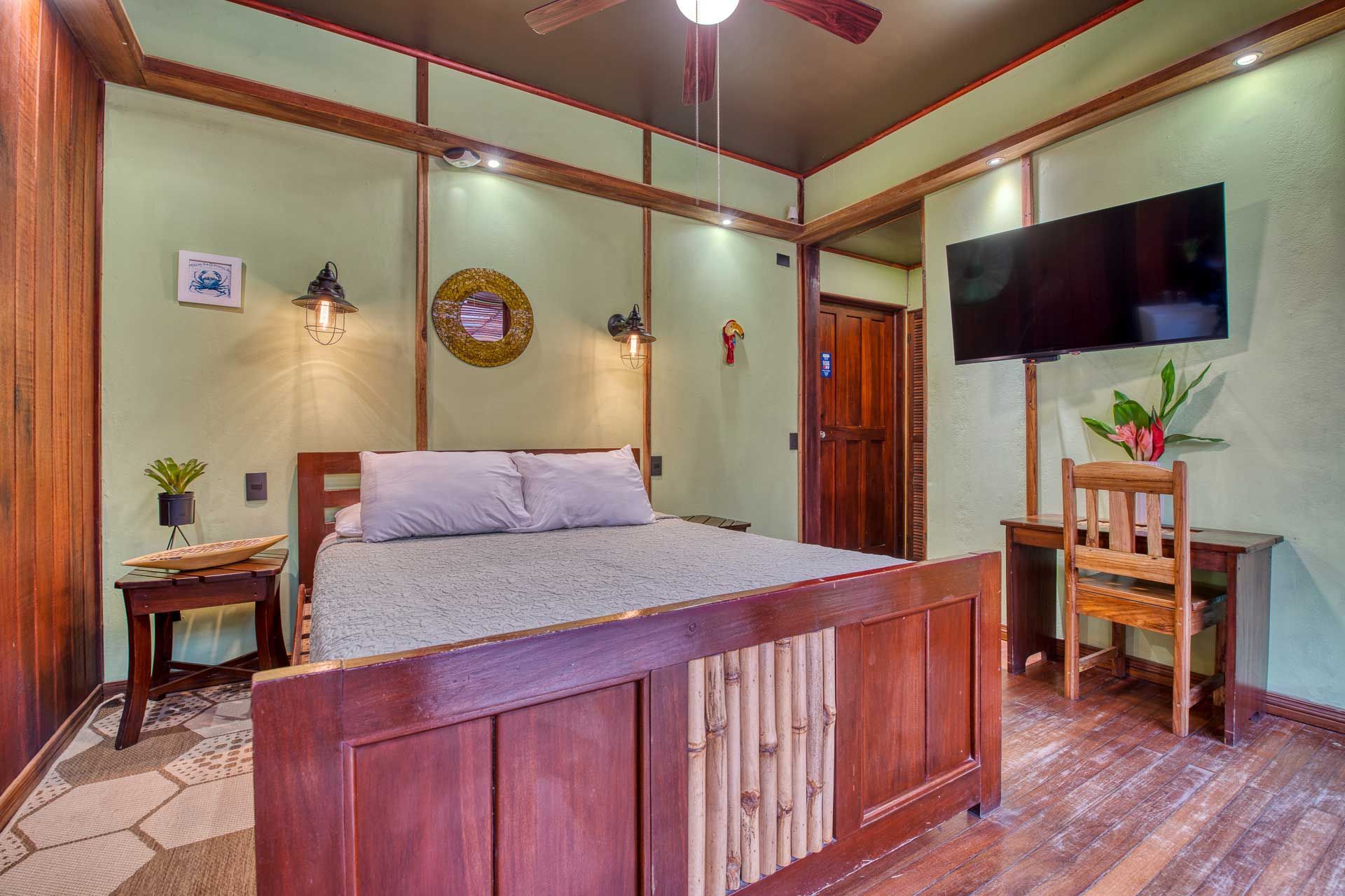 A bedroom with a bed , desk , chair and television.