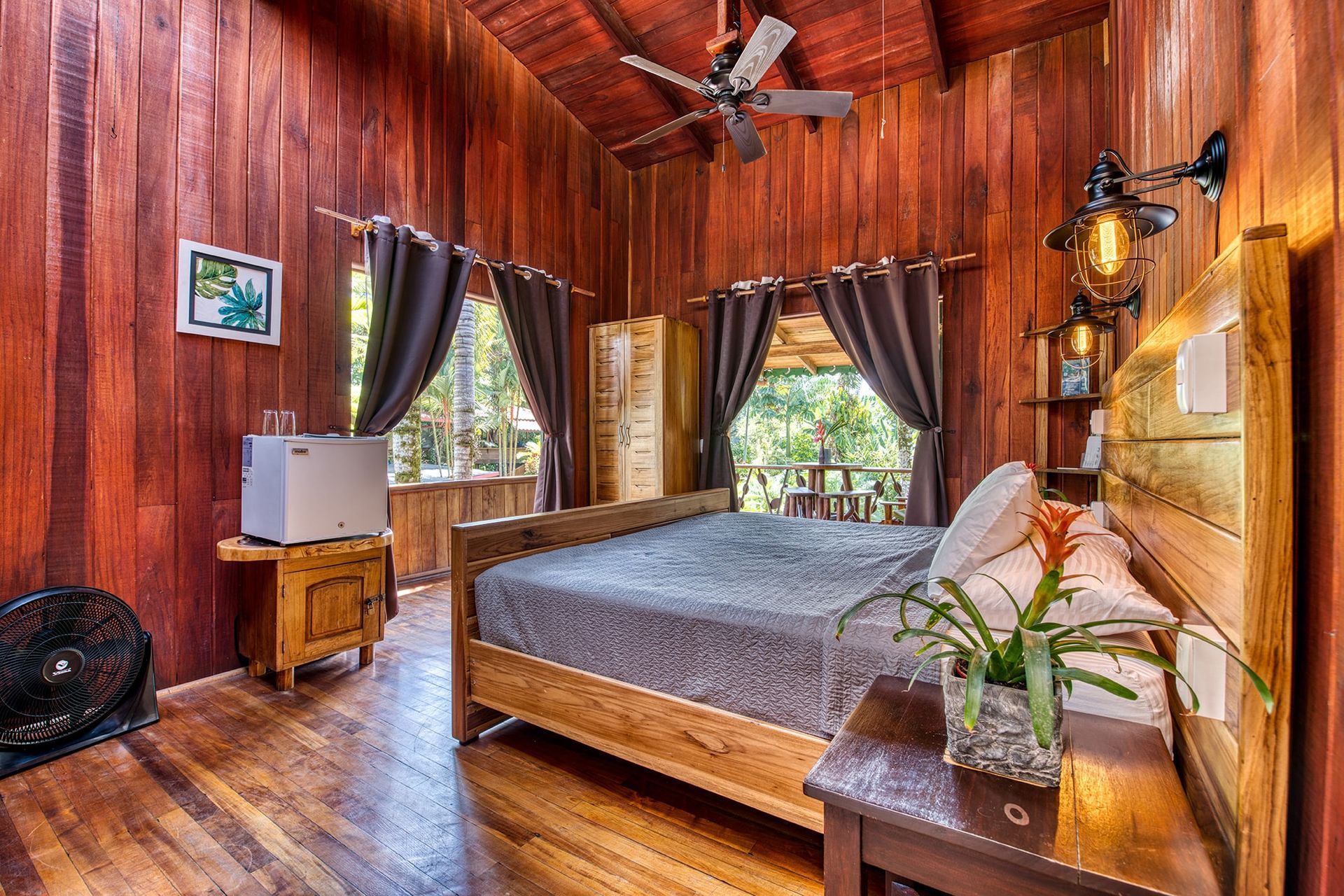 A bedroom with a bed , nightstand , and ceiling fan.