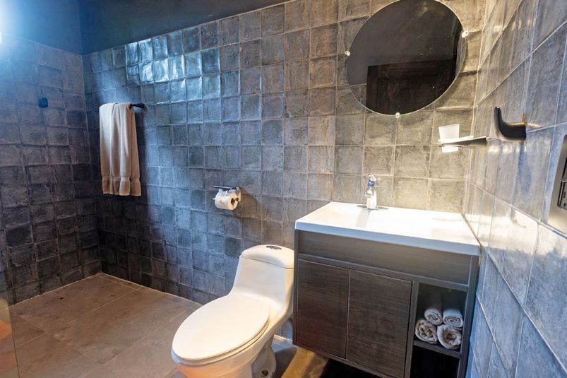 A bathroom with a toilet , sink and mirror.