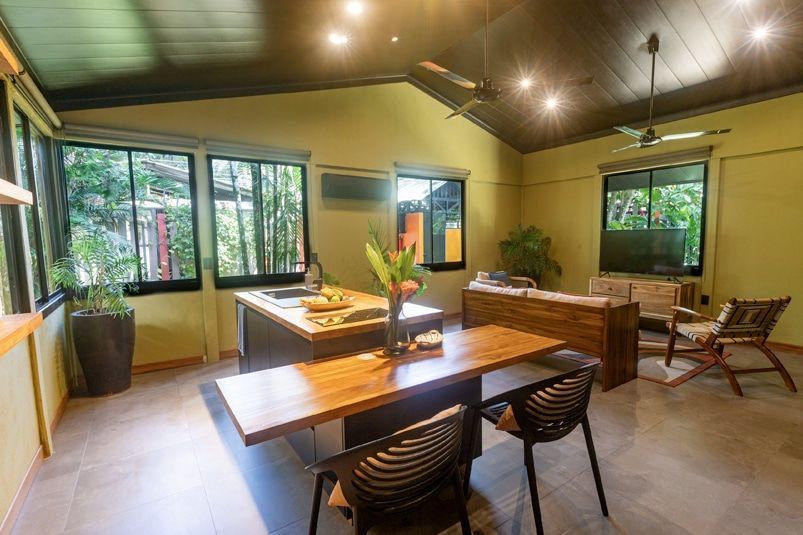 A living room with a table and chairs and a ceiling fan.