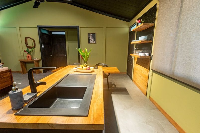 A kitchen with a sink and a wooden counter top.